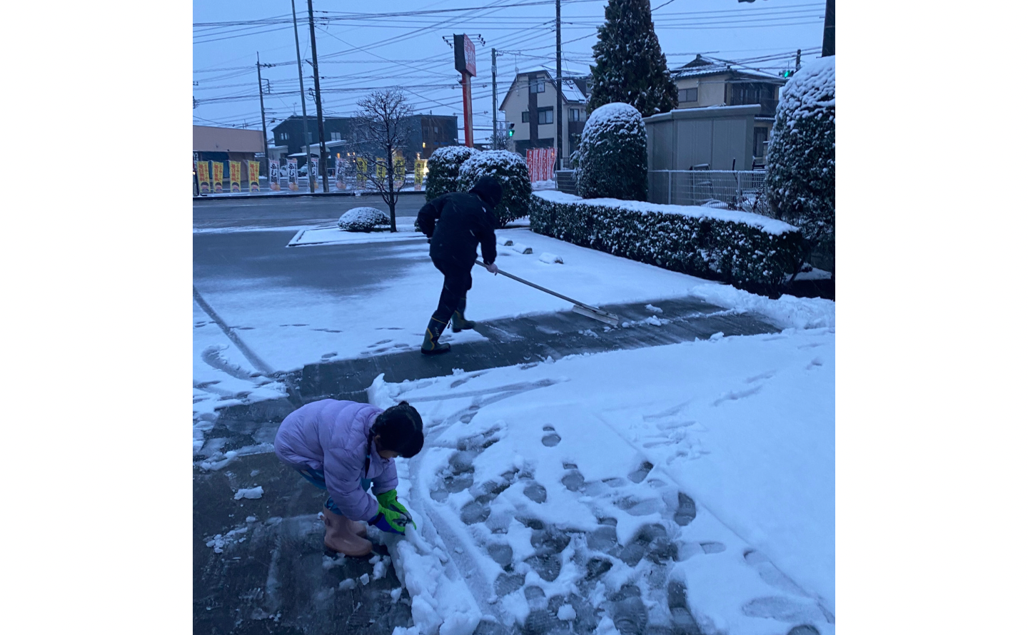 雪かきする院長