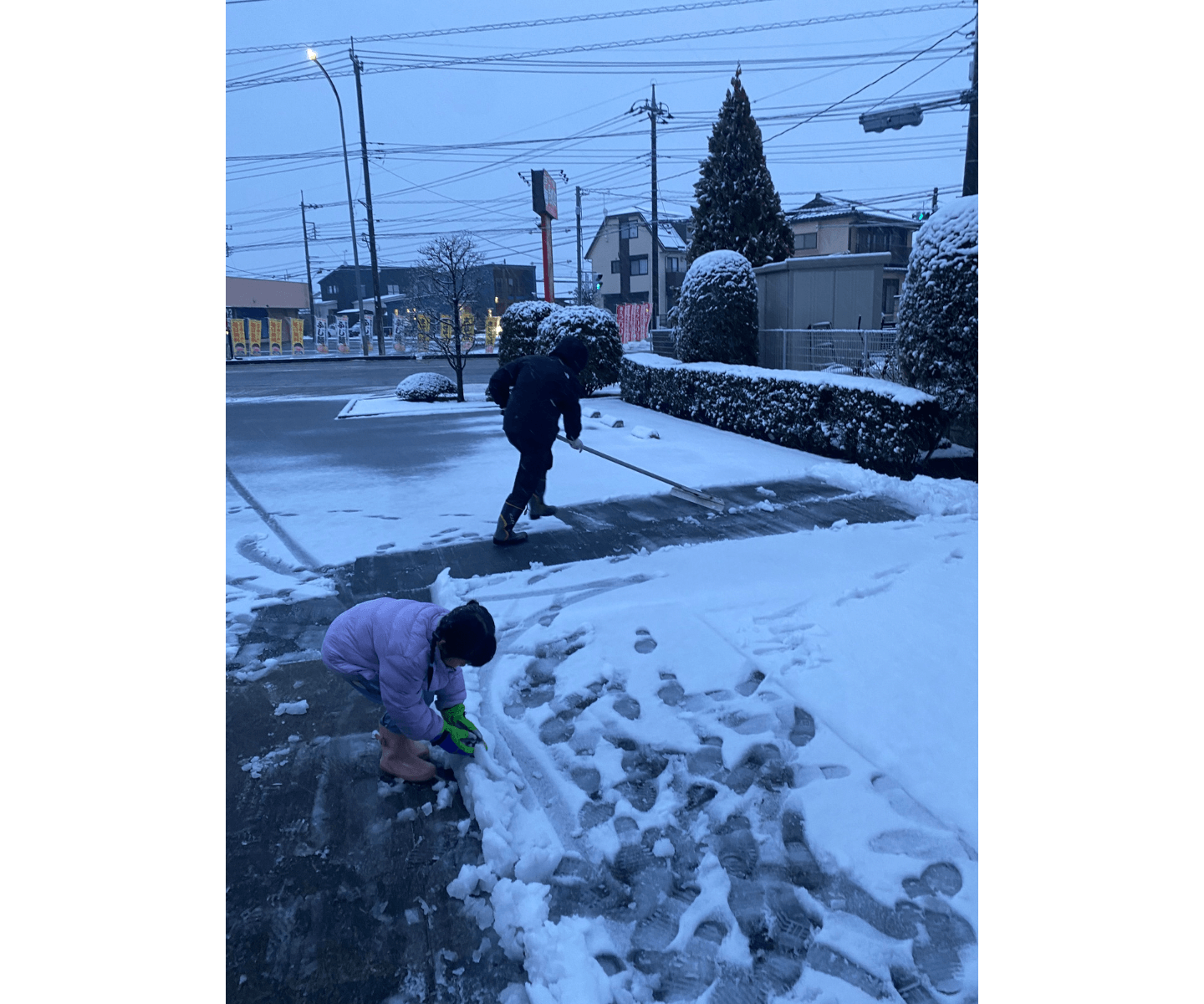 雪かきする院長